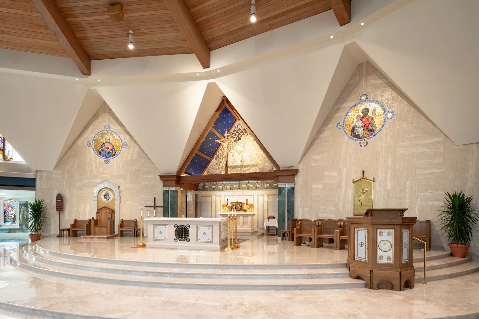 The beautified sanctuary from the nave: the baldachin over the altar beneath the folded ceiling, painted roundels either side and the cathedra at right.
