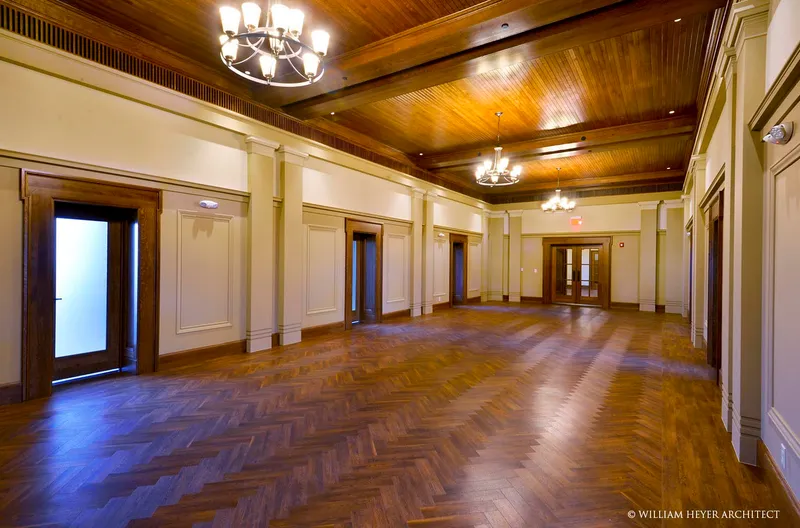 The corridor from the entrance, the glazed door at left, herringbone floor and panelled walls leading to the far end.